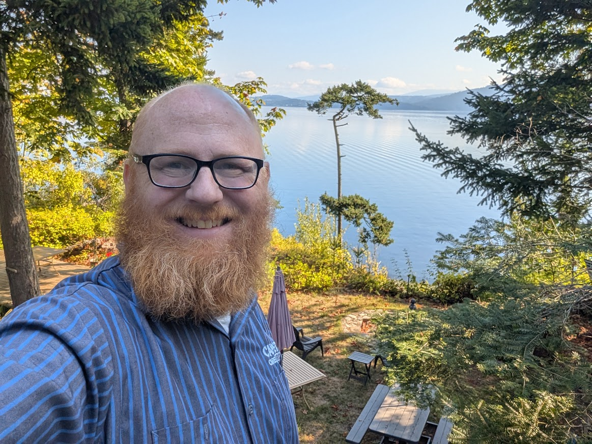 Gavin Green on Eliza Island with a view of the water and islands behind him